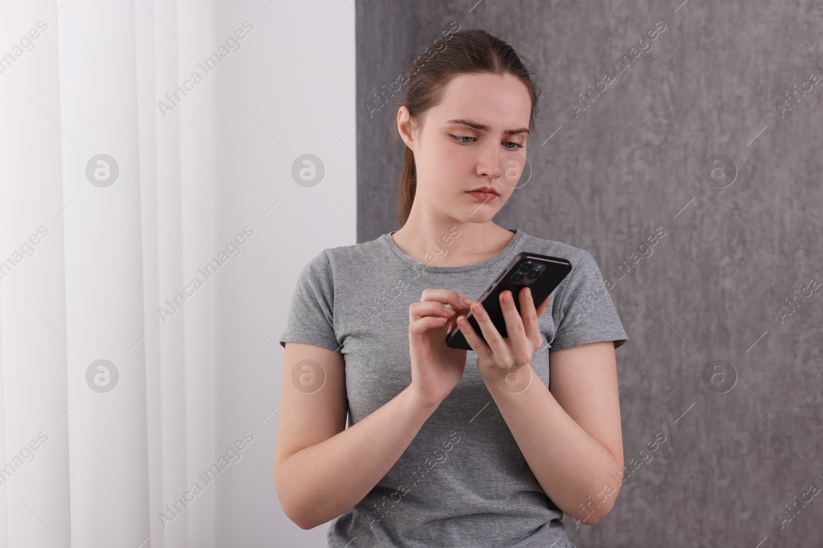 Photo of Stressed woman calling hotline for mental health help near window at home. Space for text