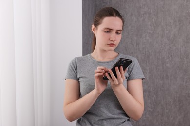 Photo of Stressed woman calling hotline for mental health help near window at home. Space for text