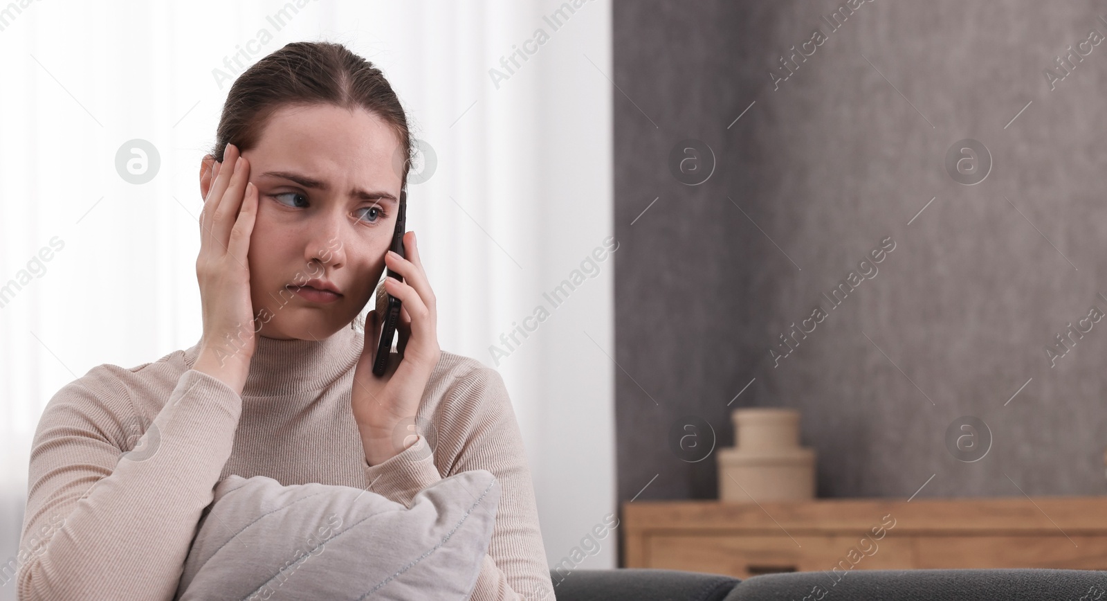 Photo of Stressed woman calling hotline for mental health help at home. Space for text