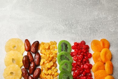 Photo of Different dried fruits on light table, flat lay. Space for text