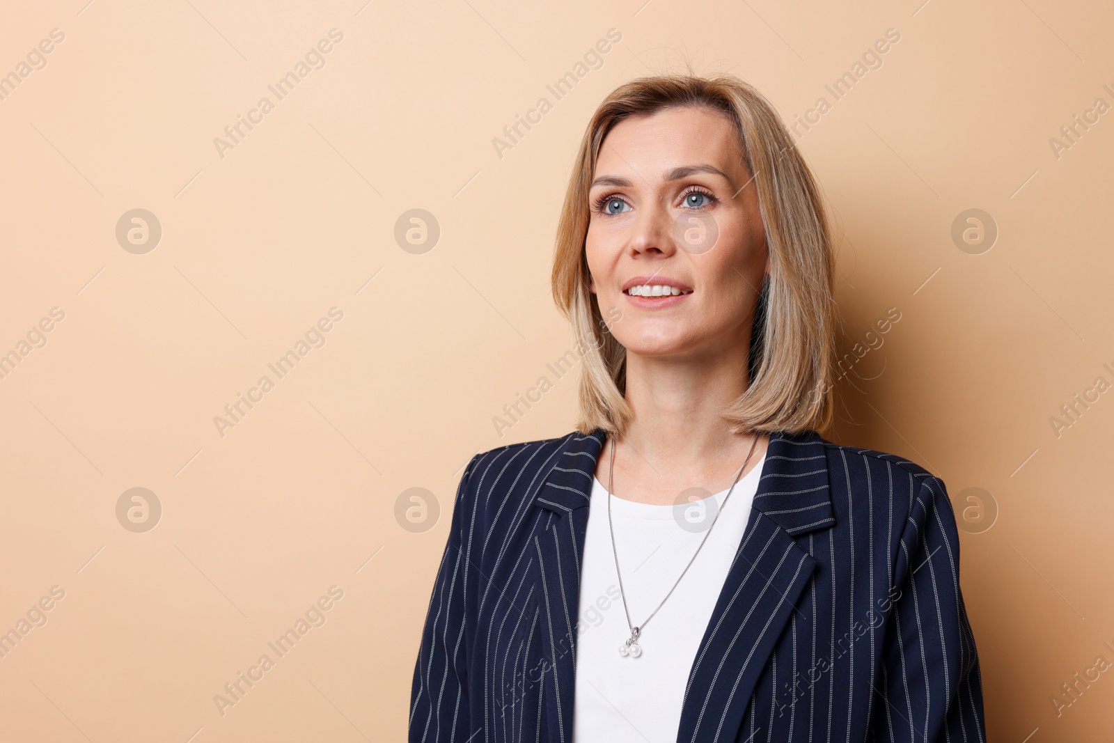 Photo of Portrait of happy businesswoman on beige background, space for text