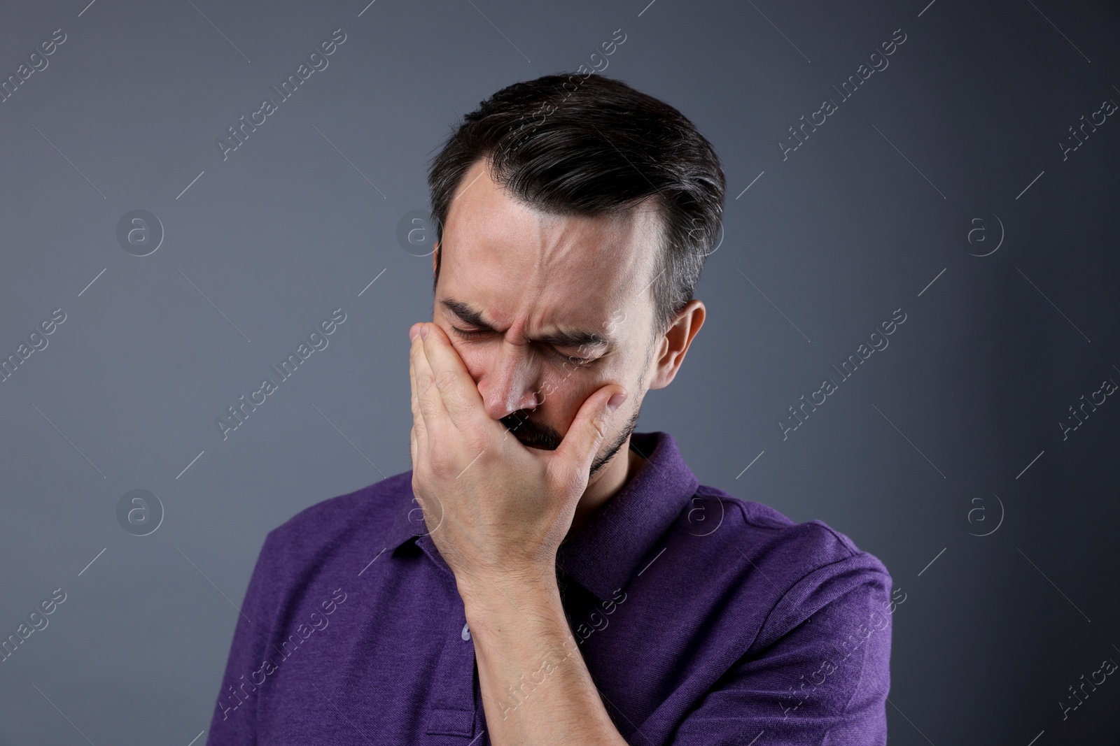 Photo of Portrait of sad man crying on grey background