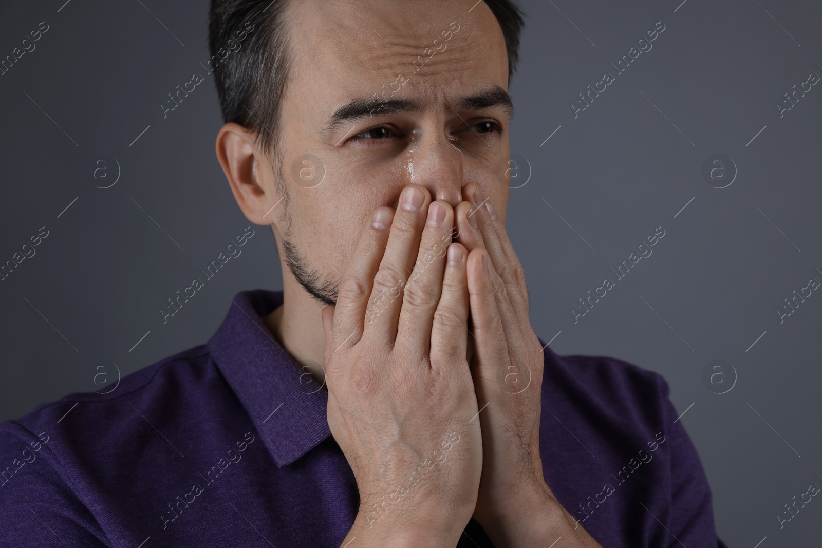 Photo of Portrait of sad man crying on grey background