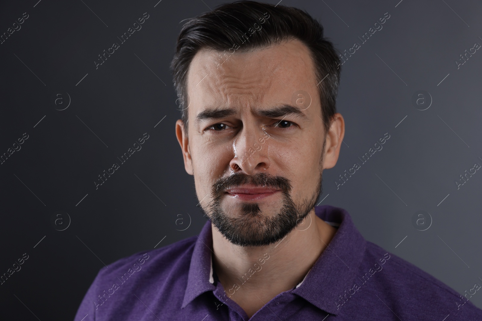 Photo of Portrait of sad man crying on grey background