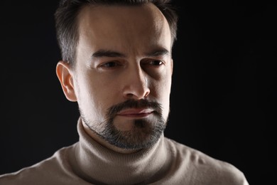 Photo of Portrait of sad man crying on black background