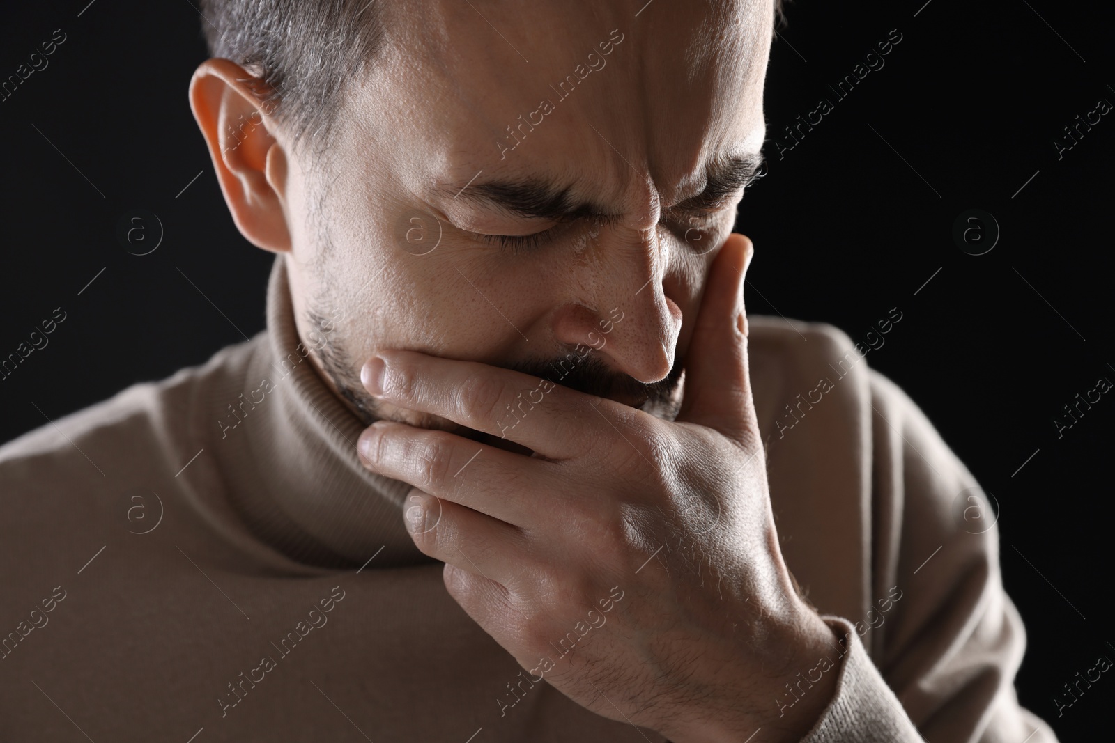 Photo of Portrait of sad man crying on black background