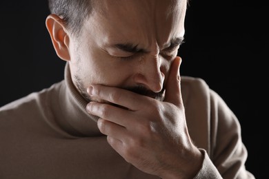 Photo of Portrait of sad man crying on black background