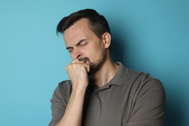 Photo of Sad man crying on light blue background