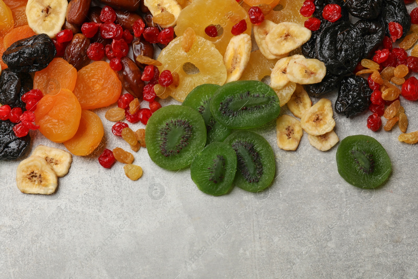 Photo of Mix of different dried fruits on grey table, top view