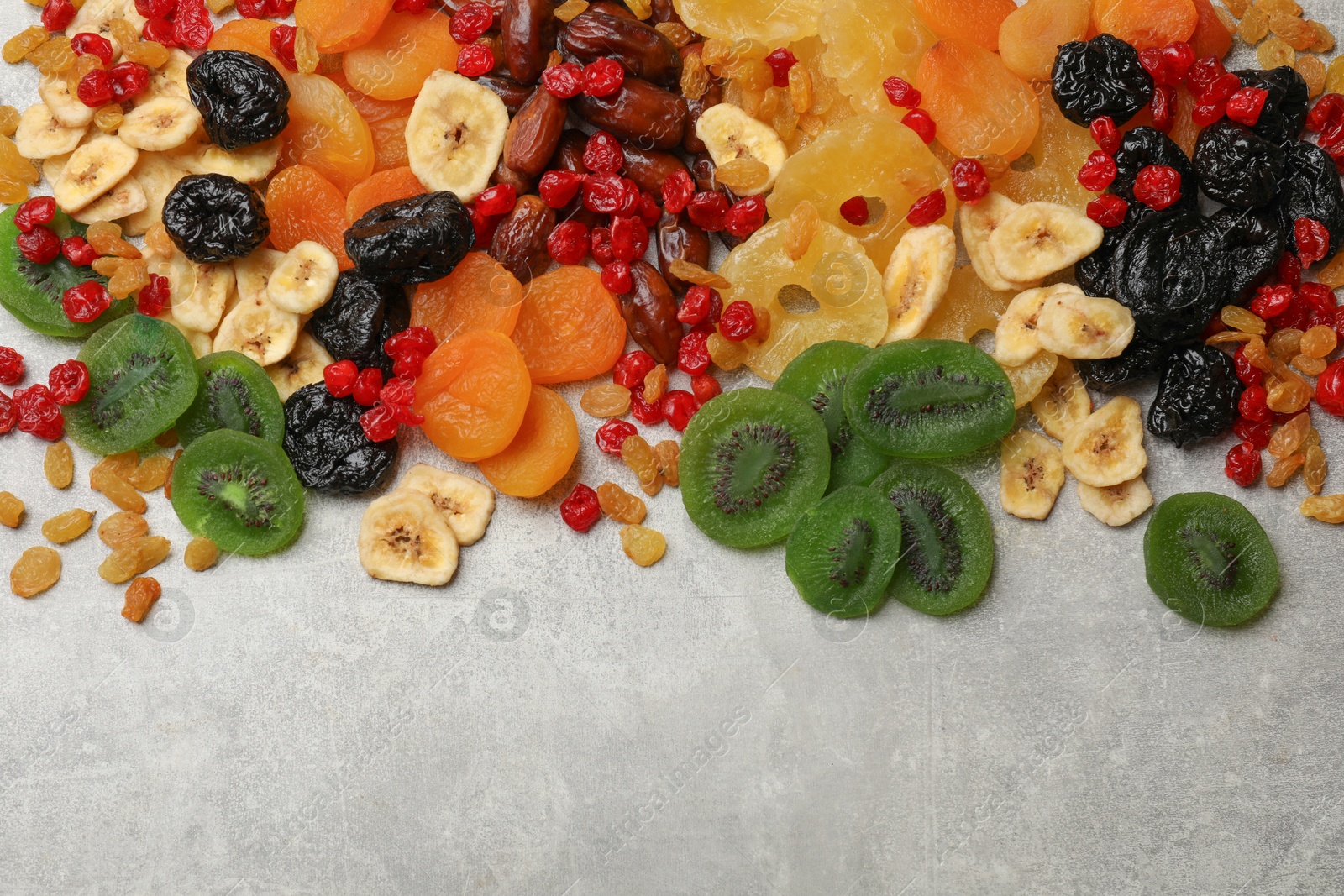 Photo of Mix of different dried fruits on grey table, top view