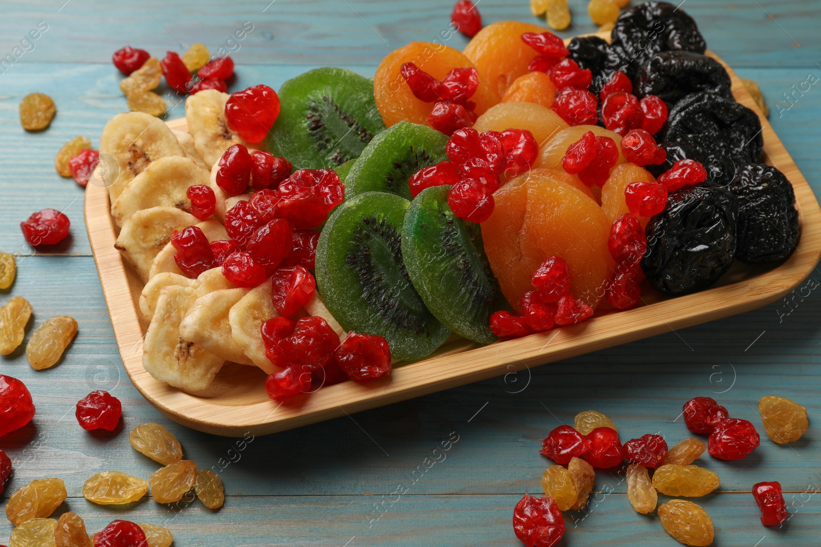 Photo of Different dried fruits on blue wooden table, closeup