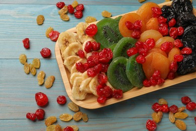 Photo of Different dried fruits on blue wooden table, closeup