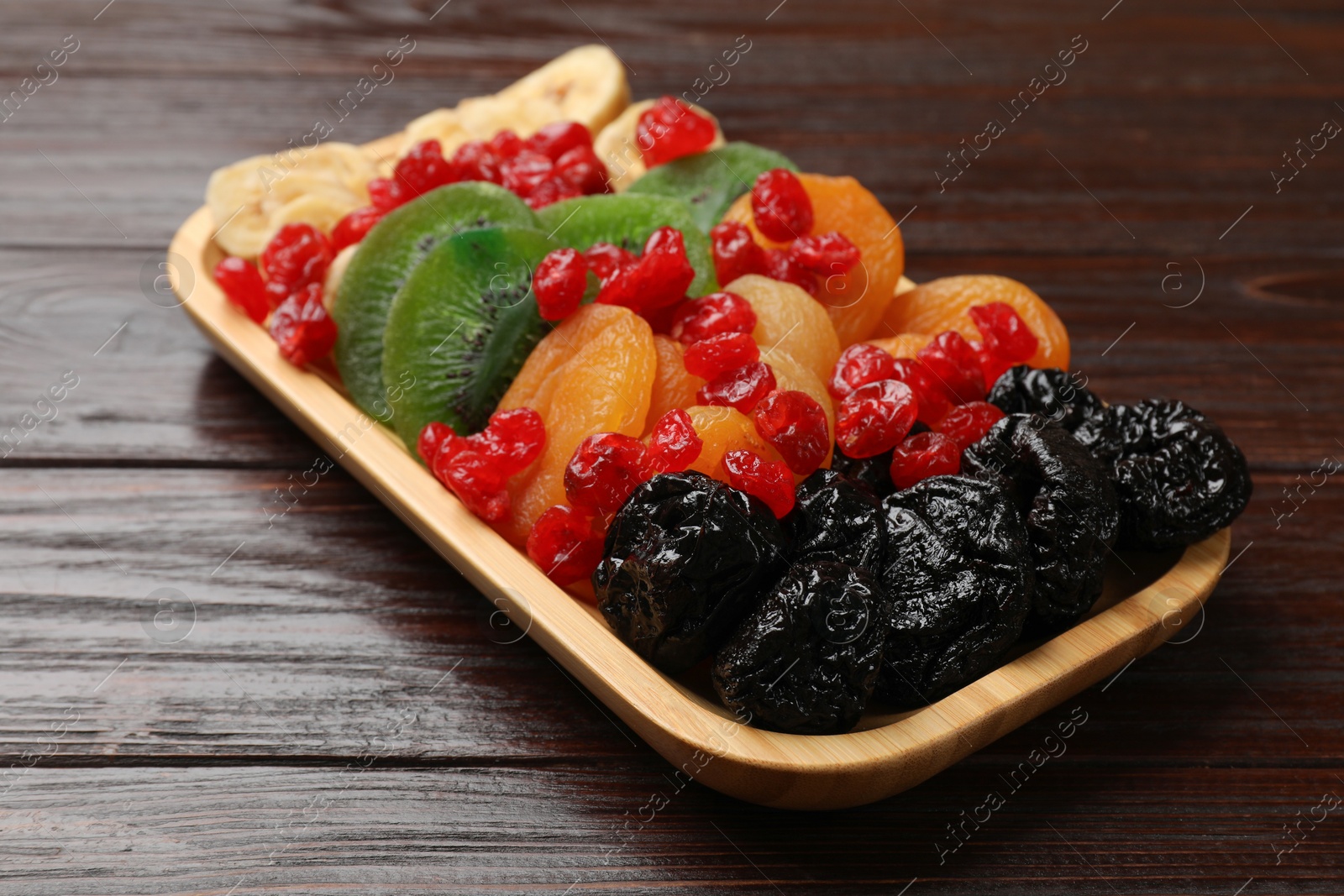 Photo of Different dried fruits on wooden table, closeup