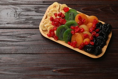 Photo of Different dried fruits on wooden table, top view. Space for text