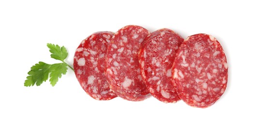 Photo of Pieces of delicious dry cured sausage and parsley isolated on white, top view