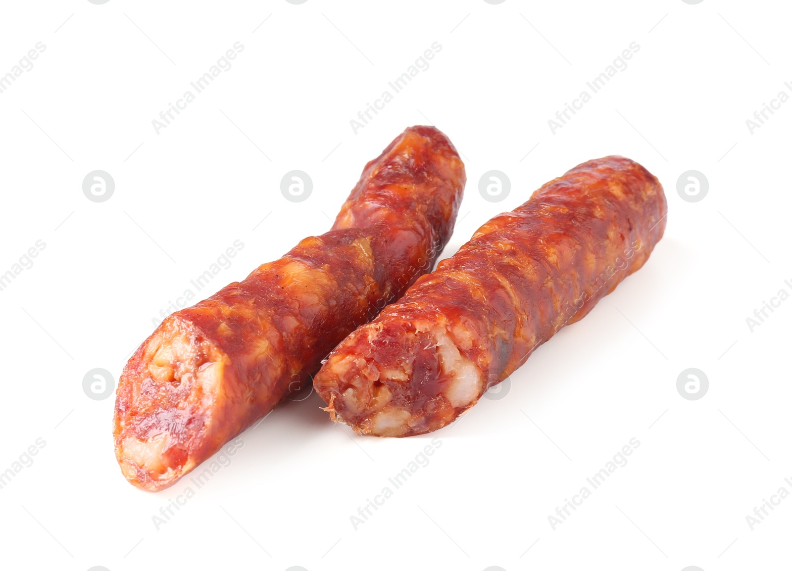 Photo of Pieces of delicious thin dry cured sausage isolated on white