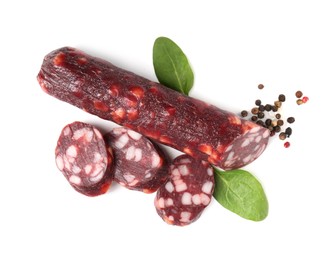 Photo of Delicious dry cured sausage and spices isolated on white, top view