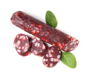 Photo of Delicious dry cured sausage and spinach isolated on white, top view