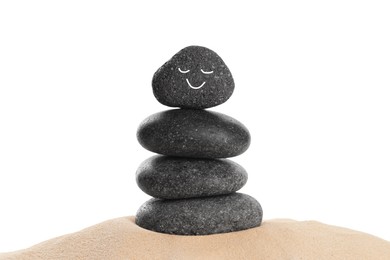 Photo of Stack of stones with drawn smiley face on sand against white background. Harmony and life balance