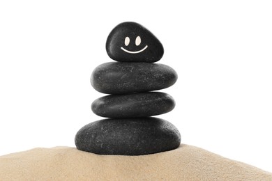 Photo of Stack of stones with drawn smiley face on sand against white background. Harmony and life balance