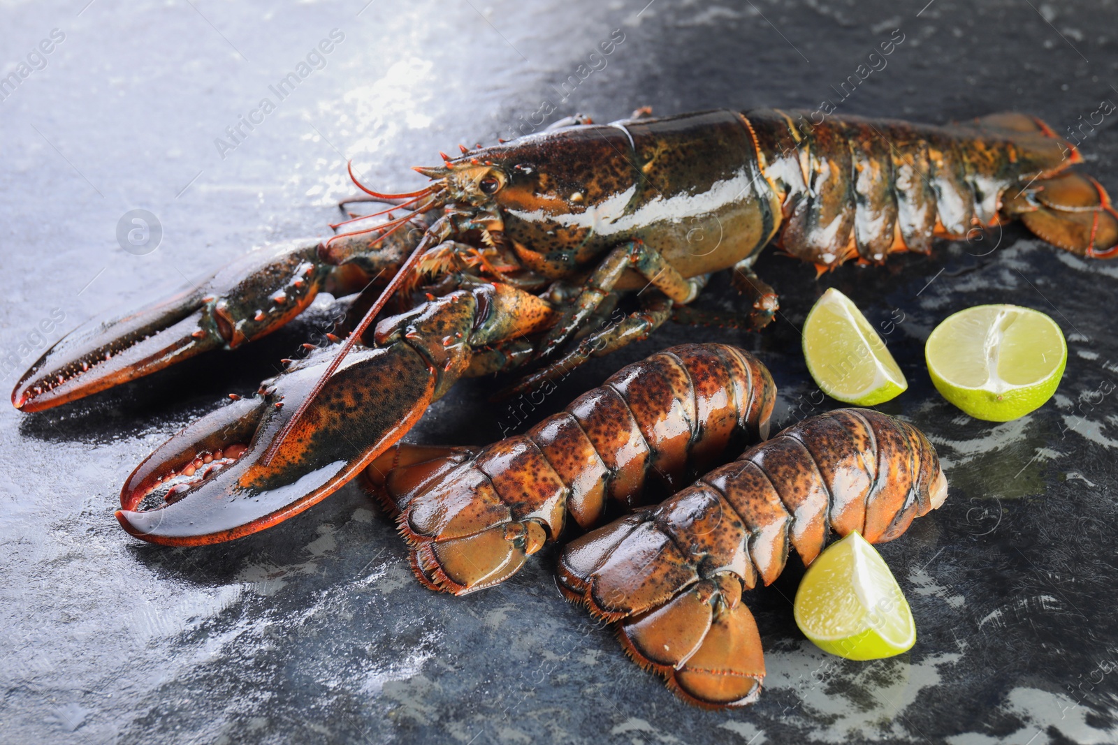 Photo of Raw lobster, tails and lime on dark table