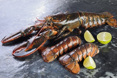 Photo of Raw lobster, tails and lime on dark table