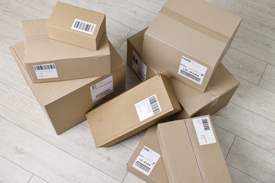 Photo of Cardboard parcel boxes with shipping labels on floor indoors, above view