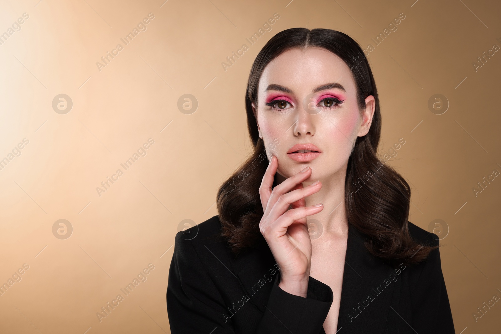 Photo of Portrait of beautiful young woman with stylish makeup and gorgeous hair on beige background. Space for text