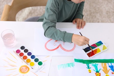 Photo of Little boy drawing at white table indoors, above view