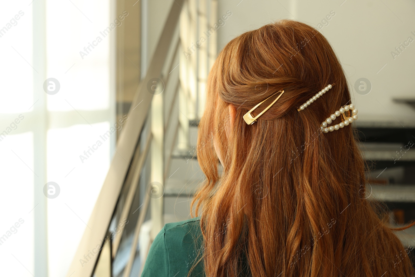 Photo of Teenage girl with stylish hair clips indoors, back view. Space for text