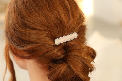 Photo of Teenage girl with stylish hair clip indoors, back view