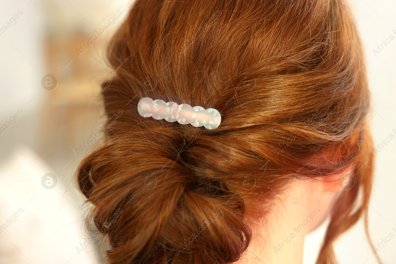 Photo of Teenage girl with stylish hair clip indoors, back view