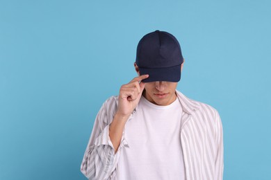 Photo of Man in stylish baseball cap on light blue background. Mockup for design