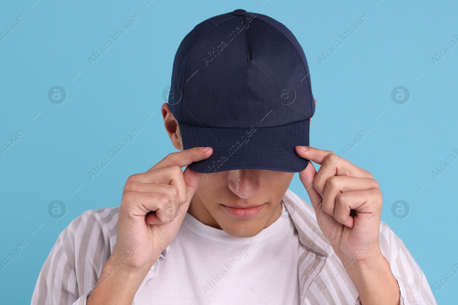 Photo of Man in stylish baseball cap on light blue background. Mockup for design