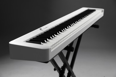 Photo of Synthesizer on grey background, closeup. Electronic musical instrument