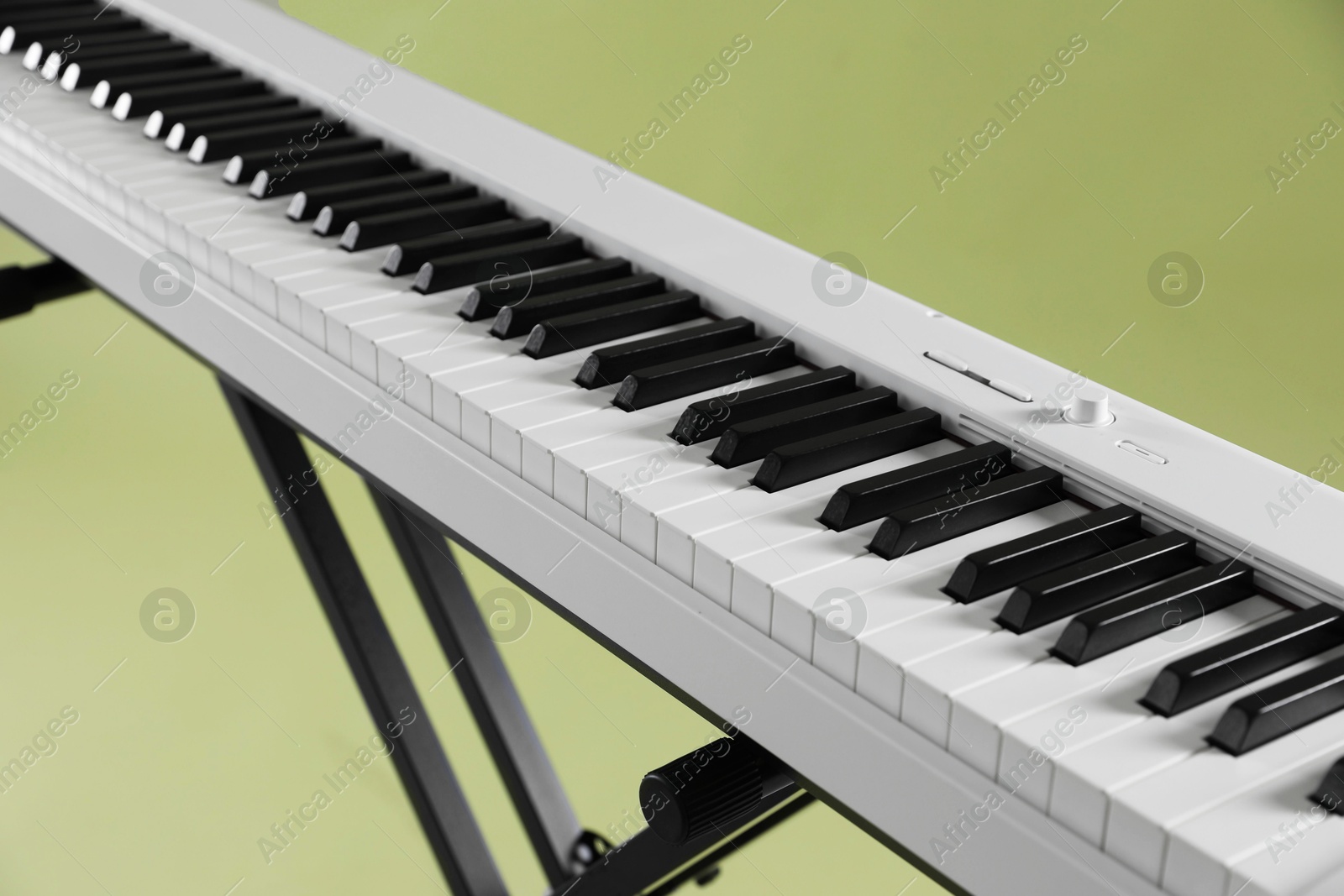 Photo of Synthesizer on green background, closeup. Electronic musical instrument