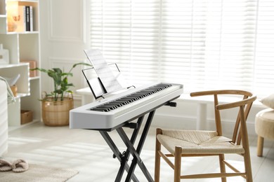 Photo of Synthesizer with music sheet and chair at home