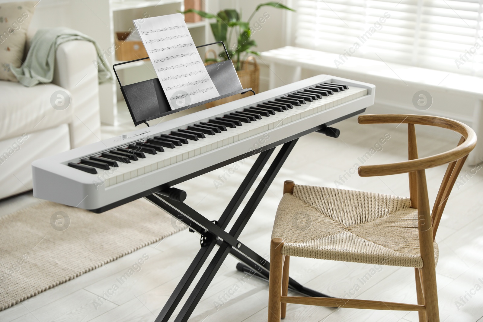 Photo of Synthesizer with music sheet and chair at home