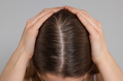 Photo of Girl with hair loss problem on grey background, closeup