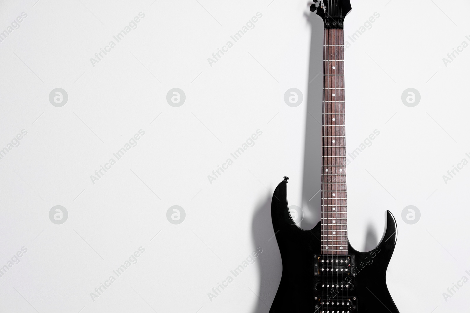 Photo of One modern electric guitar on white background. Space for text