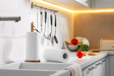 Photo of Rolls of paper towels on white countertop near sink in kitchen, space for text