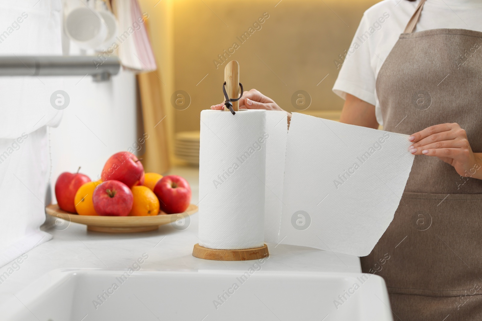 Photo of Woman using paper towels in kitchen, closeup