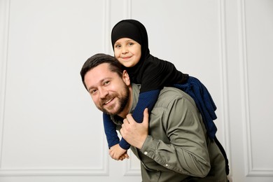 Photo of Muslim man and his daughter spending time together at home