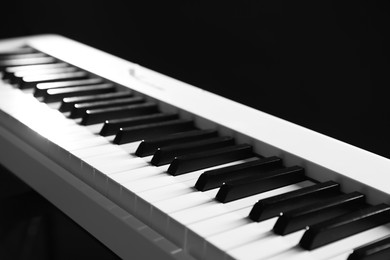 Photo of Synthesizer on black background, closeup. Electronic musical instrument