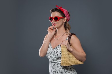 Photo of Happy pin-up woman with bag on grey background