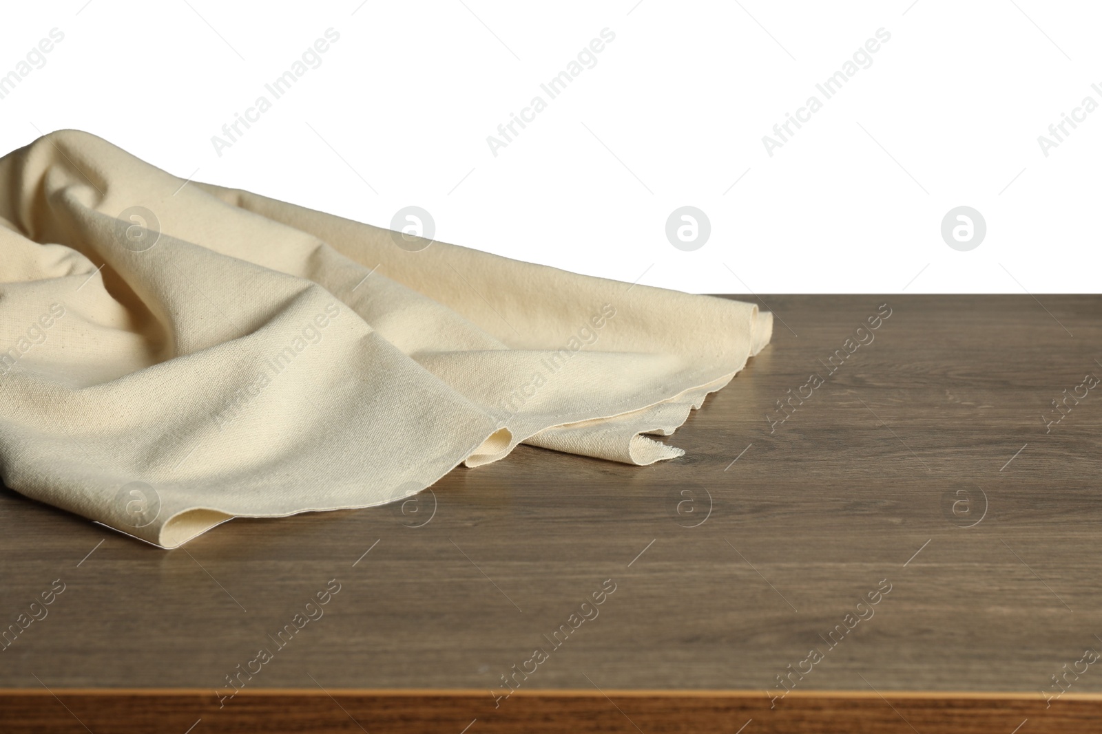 Photo of Beige tablecloth on wooden table against white background, closeup