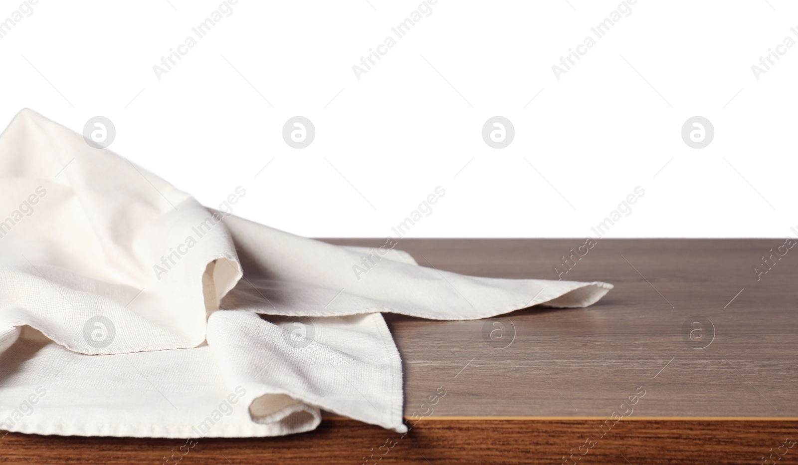 Photo of Light tablecloth on wooden table against white background, closeup