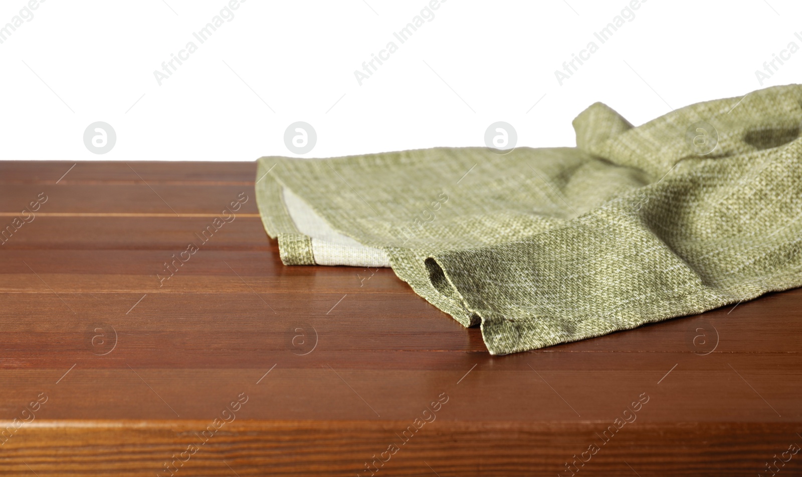 Photo of Green tablecloth on wooden table against white background, closeup