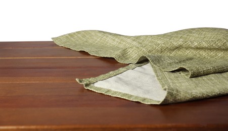 Photo of Green tablecloth on wooden table against white background, closeup