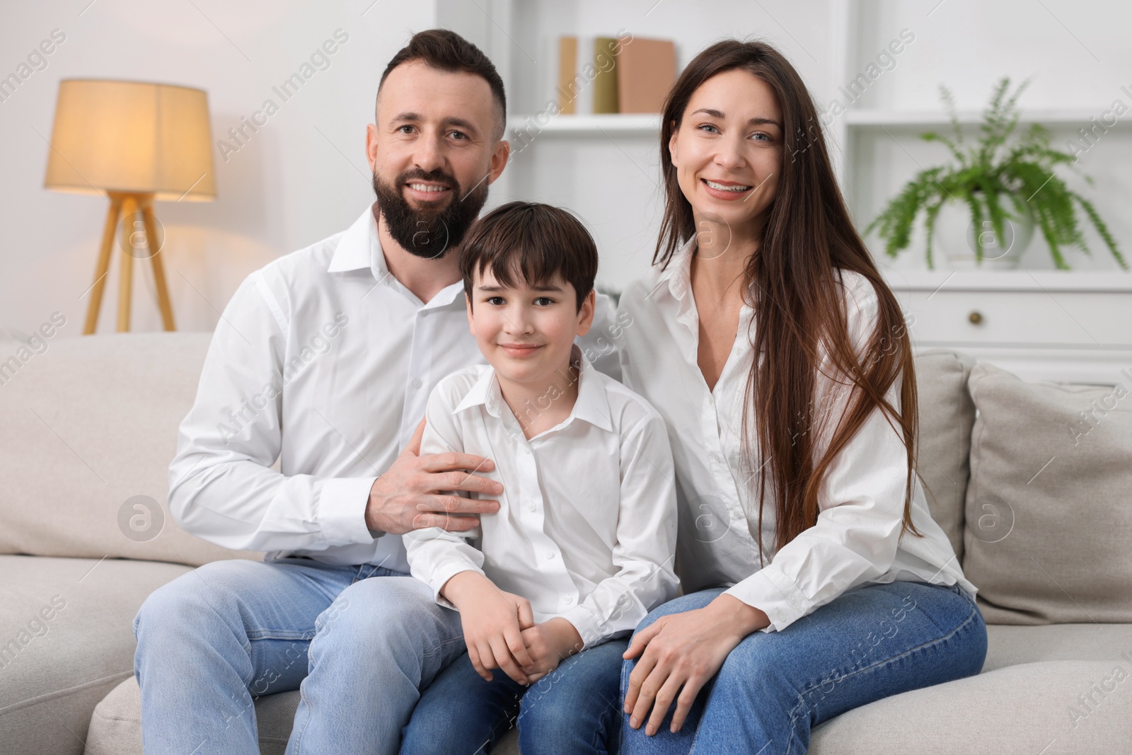 Photo of Happy parents and their son on sofa at home